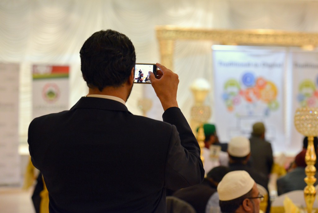 Member of the audience taking a picture at the Imams Online Digital Summit in Manchester