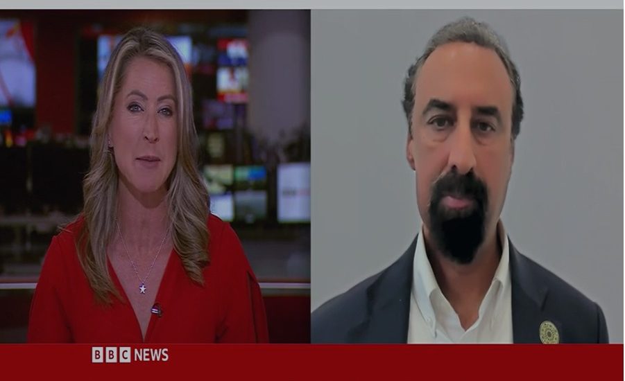 BBC News presenter interviewing a Faith Associates representative about mosque security